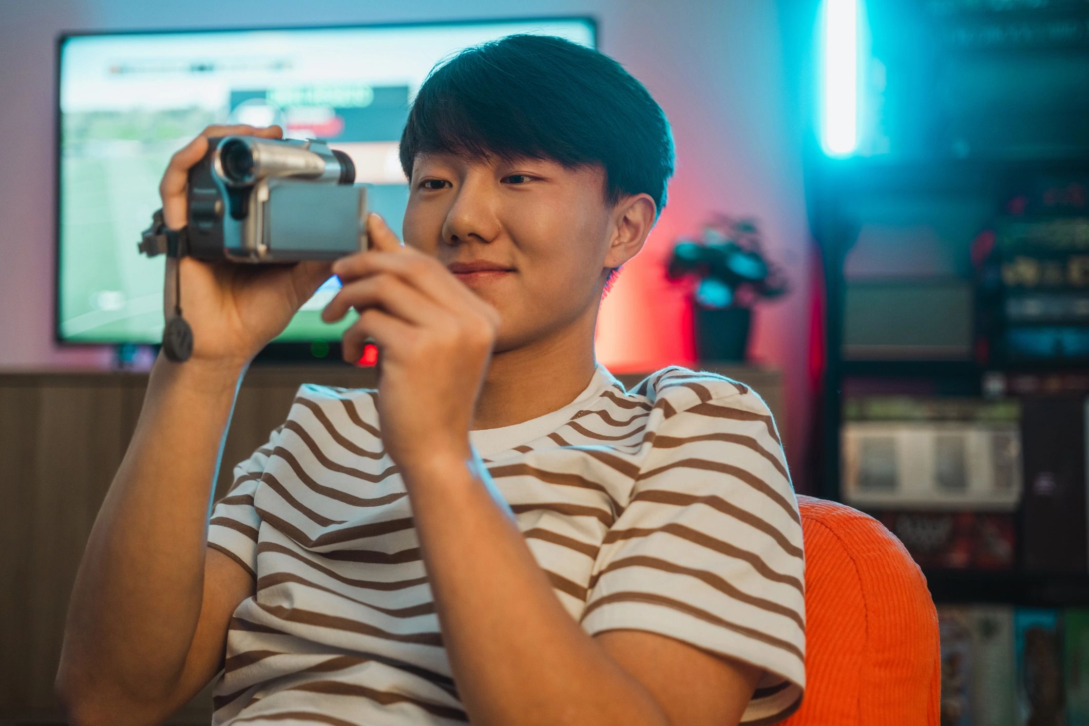 Person examining vintage video equipment at home